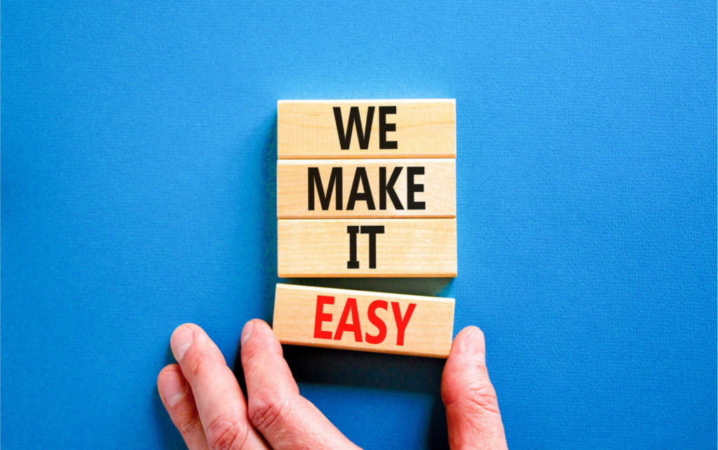 Wooden blocks on a blue background displaying the phrase "We Make It Easy," with the word "Easy" in red. This represents simplifying processes like aircraft booking with PreFlight, making them efficient and hassle-free.