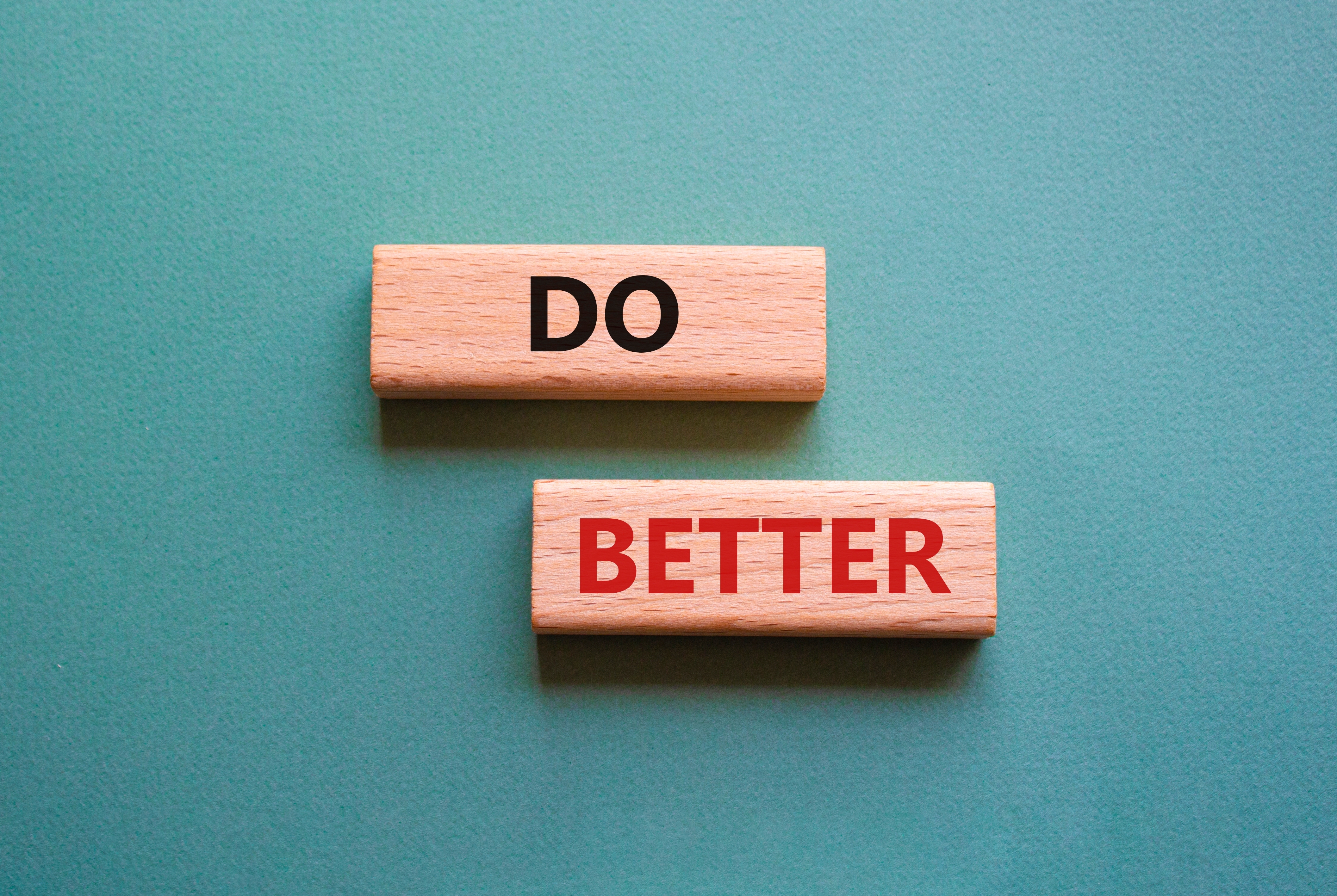 Two wooden blocks with the words 'DO' and 'BETTER' symbolizing continuous improvement in flight planning, set against a teal background.